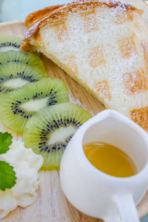 Kiwi waffle with honey  on wooden plateの写真素材