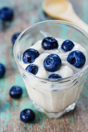 fresh bilberry yogurt in a glass on woodenの写真素材