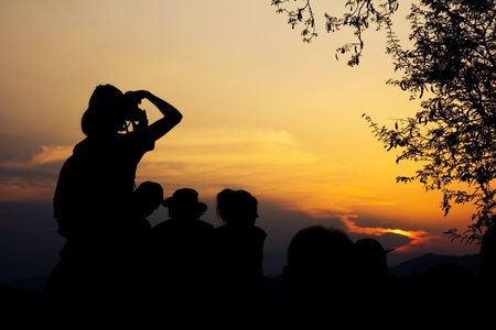 Silhouette of travelers with camera during sunset at That Phu Si and Wat tham Phu Si, Luang Prabang...