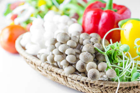 Fresh mushroom, yellow and red pepper,Sunflower sprouts in a basket on a white backgroundの写真素材