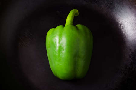 Green peppers on dark frying panの写真素材