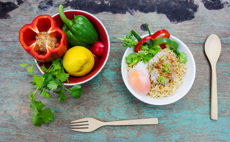 Chinese noodles with minced pork and egg in bowl on wooden tableの写真素材