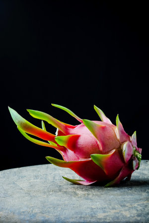 Dragon Fruit on wooden background, image dark tone.
