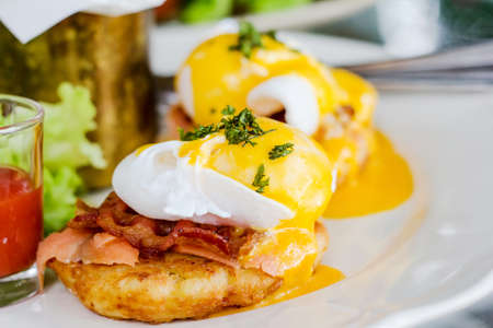 Eggs Benedict- toasted English muffins, ham, poached eggs, and delicious buttery hollandaise sauceの写真素材