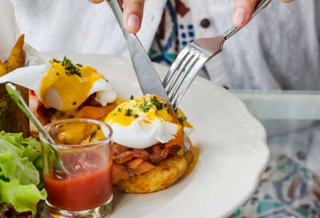 Eggs Benedict- toasted English muffins, ham, poached eggs, and delicious buttery hollandaise sauceの写真素材