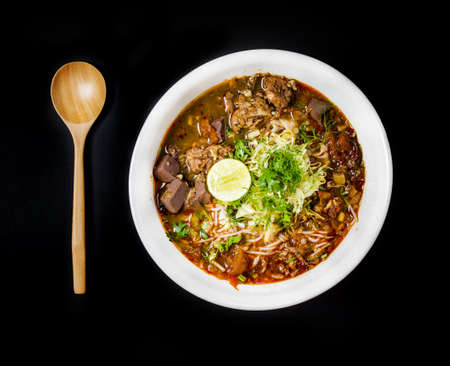 Rice noodles with spicy pork sauce (Nam ngiao) on black table, Thai food.の写真素材