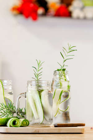 glass jars of cucumber and rosemary on wooden tableの写真素材