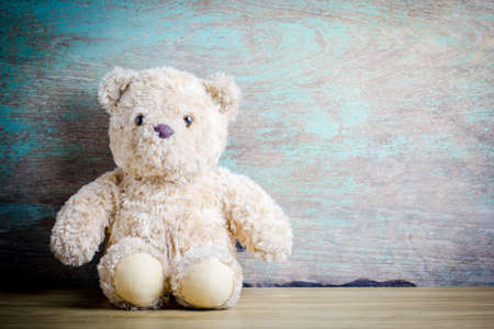Cute teddy bear on old wooden backgroundの写真素材