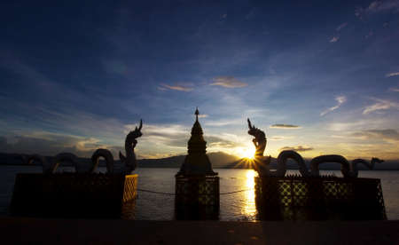 Silhouettes dragon and Naga statue on sunset at Phayao lake, Thailandの写真素材