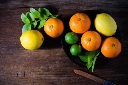 Citrus fruits. Oranges, limes and lemons. Top view over wooden table backgroundの写真素材