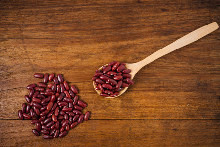 kidney beans on a wooden spoon on wooden background