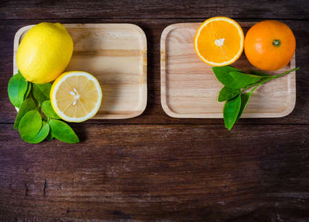 Oranges and lemons with leaves on wooden background.の写真素材