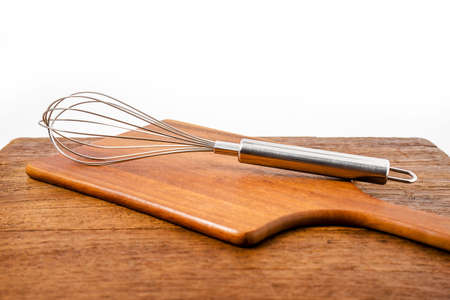 closeup whisk or egg beater on wooden tableの写真素材