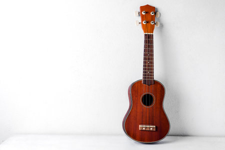 The brown ukulele on the table background