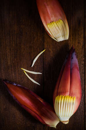 Dark food photography with banana flower on wooden background. thai food.の写真素材