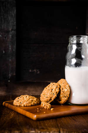 Stack of whole grains cookies with milk bottleの写真素材