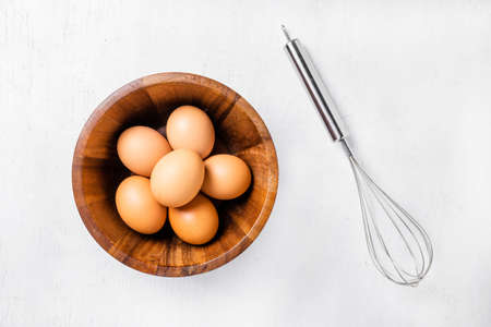 top view of eggs in bowl on white wooden background.の写真素材