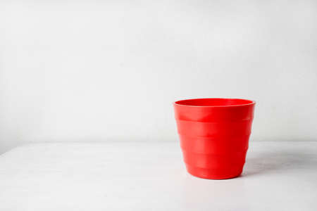 Red flower pot  on white wooden background.の写真素材