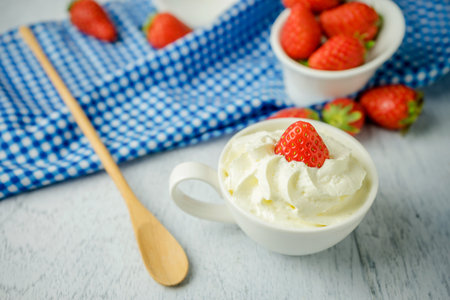 Dessert strawberries with whipped cream in a cupの写真素材