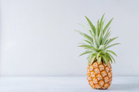 Pineapple on wooden table over white background