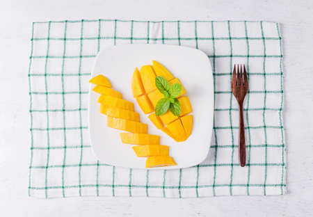 Mango fruit on white plate on tableの写真素材