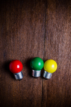top view red,green,yellow light bulbs on wooden background.の写真素材