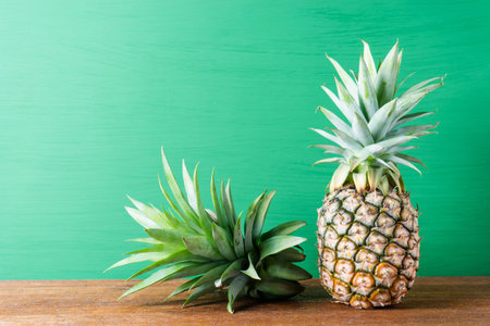 Ripe pineapple on a green wooden background