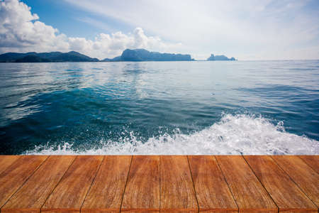 Wood table top on blurred beach background - can be used for display or montage your productsの写真素材