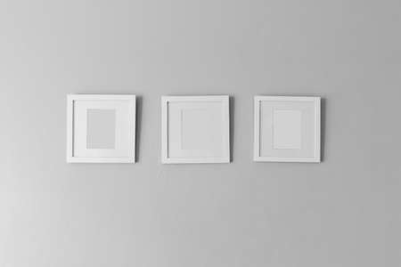Collage of three white photo frames on the wallの写真素材