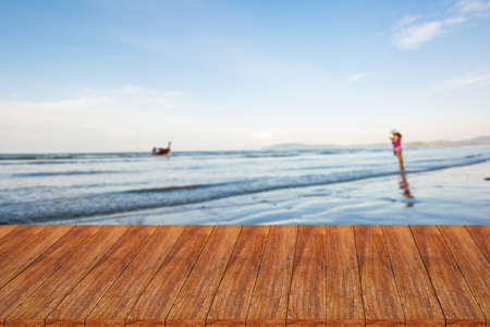 Wood table top on blurred beach background - can be used for display or montage your productsの写真素材
