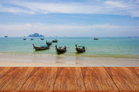 Wood table top on blurred beach background - can be used for display or montage your productsの写真素材