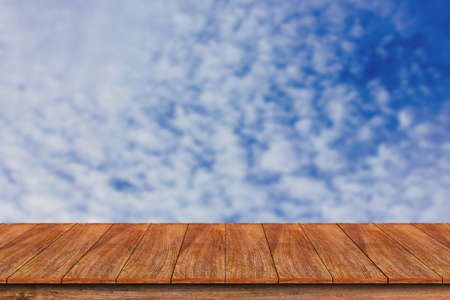 Wood table top on blurred blue sky background , can be used for display or montage your productsの写真素材