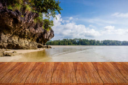 Wood table top on blurred beach background - can be used for display or montage your productsの写真素材