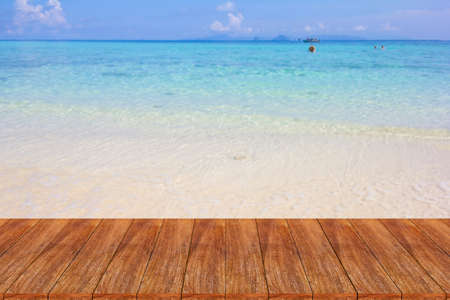 Wood table top on blurred beach background - can be used for display or montage your productsの写真素材