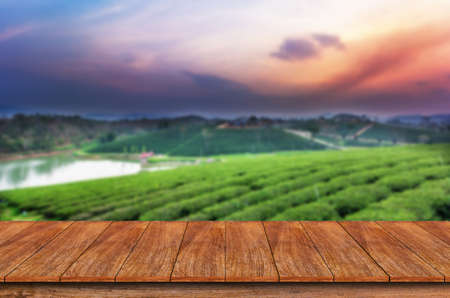 Empty wooden table and blur tea plantation background - can used for display or montage your productsの写真素材