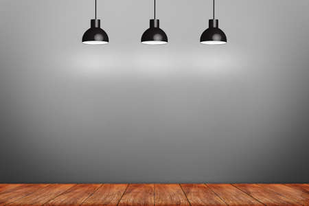 wooden laminate floor and gray wall with three ceiling lampsの写真素材
