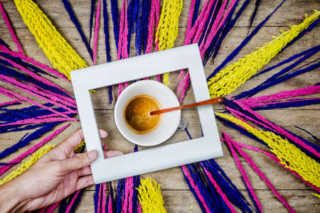 Cup of coffee and grass flowers on wooden backgroundの写真素材