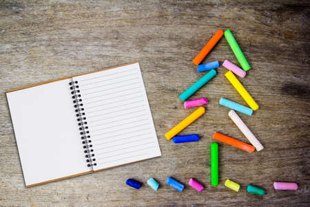 Christmas tree made of crayons and notebook on wooden backgroundの写真素材