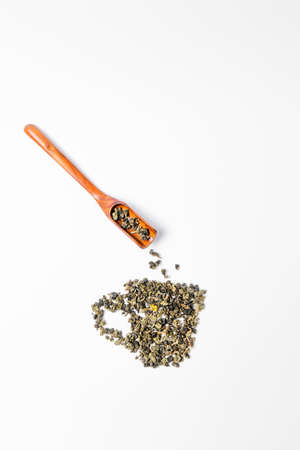 Tea leaves and wooden scoop on white background.の写真素材