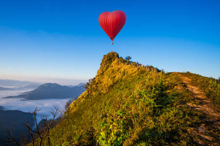 Colorful hot-air balloons flying over the mountainの写真素材