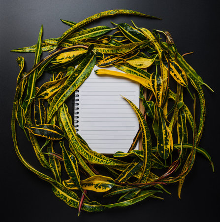 Creative layout made of leaves with paper note book. Flat lay. Nature concept