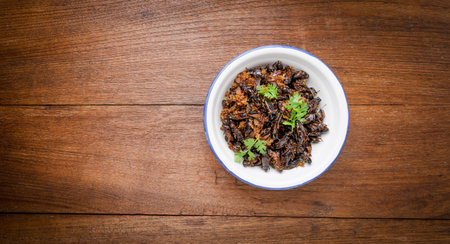 Food insect, Fried crickets in iron bowl on wooden table, Thai food.