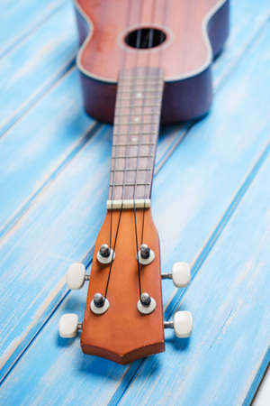 Close up of ukulele on blue wooden backgroundの写真素材