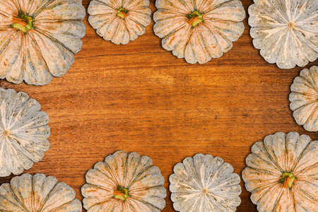 frame with pumpkins on a wooden tableの写真素材
