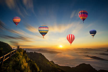 Colorful hot-air balloon flying over the mountainの写真素材