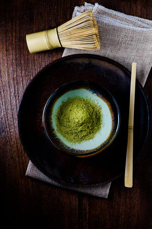 Still life with green tea and Japanese wire whisk made of bamboo for tea ceremony