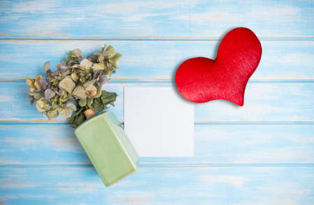 White paper mock up with dried hydrangea flowers and ceramic vase on blue backgroundの写真素材