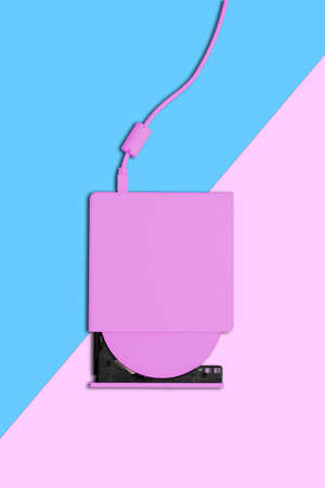 Pink slim portable dvd writer on blue and pink background.の写真素材