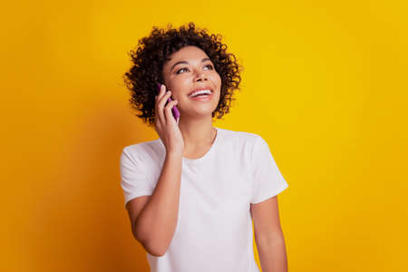 Content trendy cheerful nice cute adorable girl hold phone make call look up empty spaceの写真素材