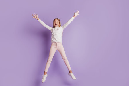 Photo of crazy sportive lady jump star shape wear white jumper posing on purple background